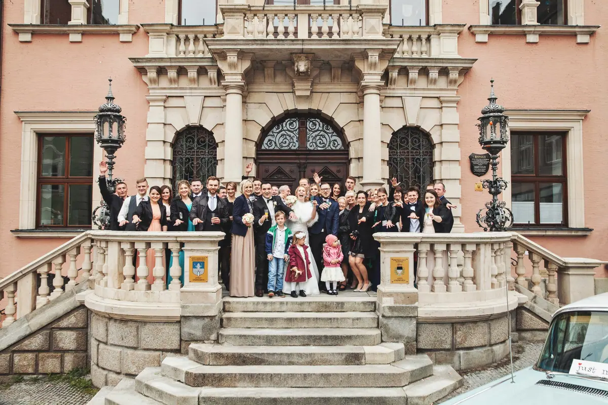 Hochzeitsgesellschaft auf der Freitreppe eines Schlosses